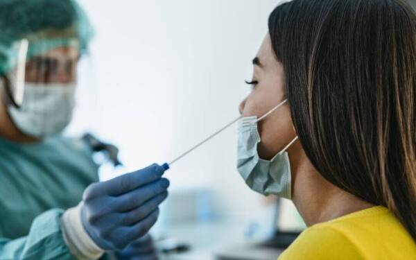 medical-worker-wearing-personal-protective-equipment-doing-corona-virus-swab-on-female-patient-covid19-test-and-health-care-concept